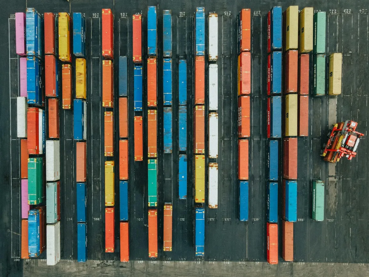 A shipping port with stacked containers representing global logistics